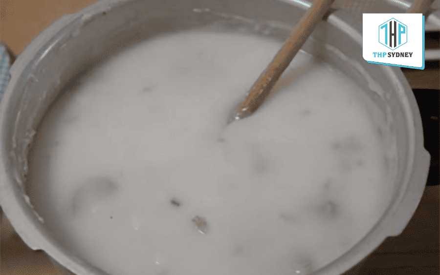 Nấu cháo với gạo ST25 trên lửa nhỏ, khuấy đều thường xuyên đến khi cháo đạt độ sánh mịn